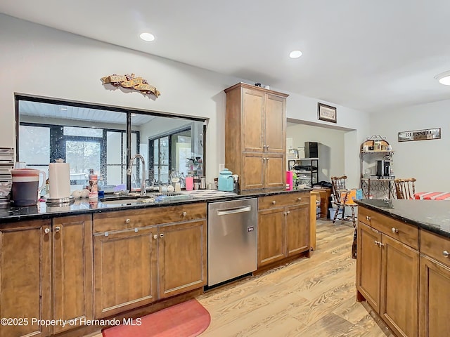 kitchen with light hardwood / wood-style floors, sink, dishwasher, and dark stone countertops