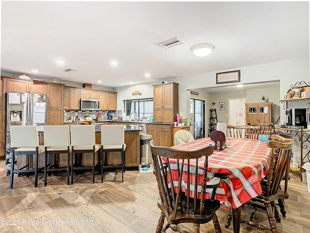 dining space featuring sink and light hardwood / wood-style floors