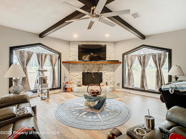 living room featuring a fireplace, lofted ceiling with beams, light hardwood / wood-style flooring, and ceiling fan