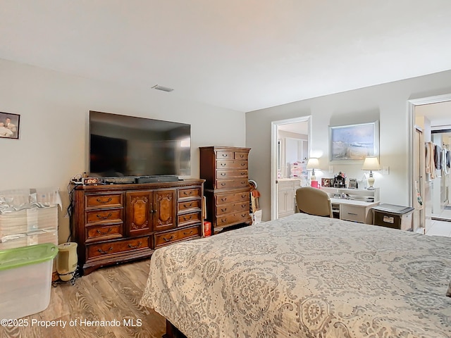 bedroom featuring light hardwood / wood-style flooring and ensuite bathroom