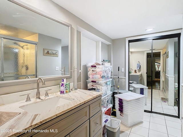 bathroom featuring vanity, a shower with door, and tile patterned flooring