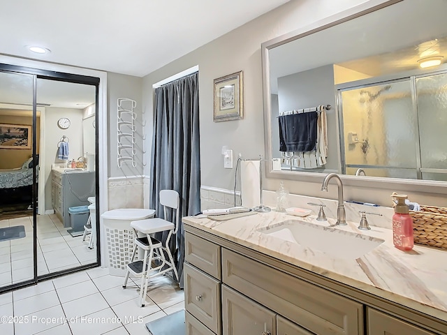 bathroom featuring vanity, a shower with shower door, and tile patterned flooring