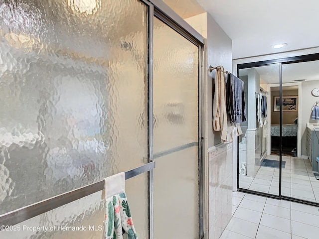 bathroom with tile walls, tile patterned floors, and walk in shower