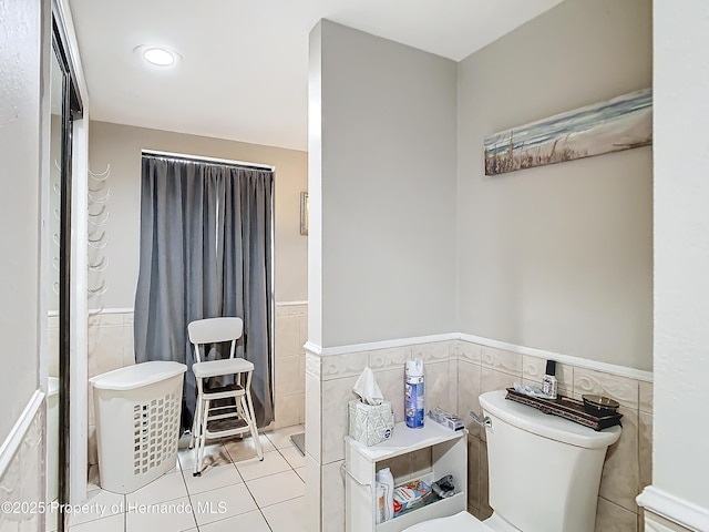 bathroom with tile walls, toilet, and tile patterned flooring