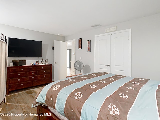 bedroom with wood-type flooring and a closet