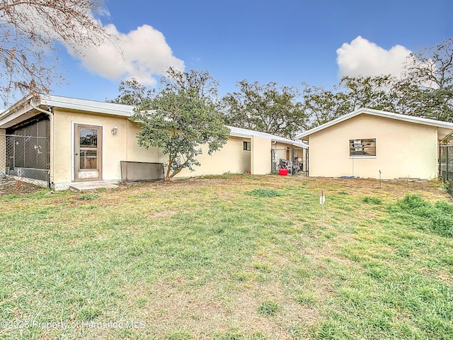 rear view of property with a lawn