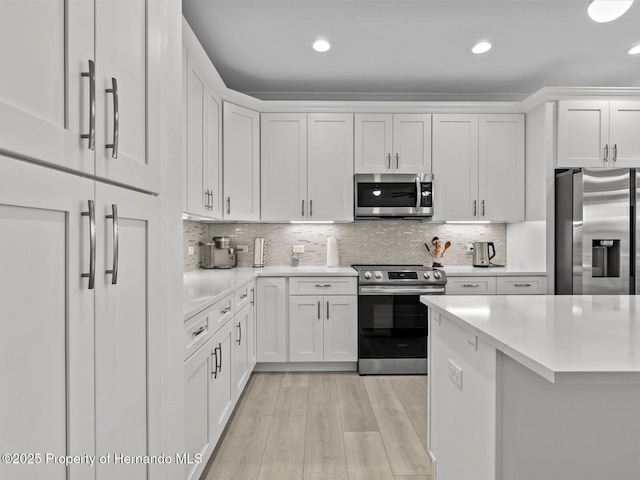 kitchen with stainless steel appliances, white cabinets, and tasteful backsplash