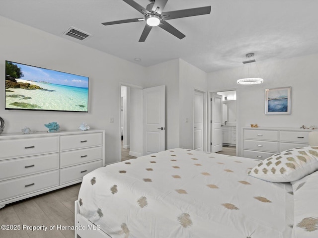 bedroom featuring ceiling fan, connected bathroom, and light hardwood / wood-style flooring