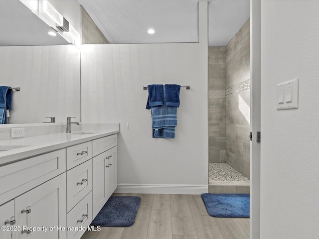 bathroom with vanity and a tile shower