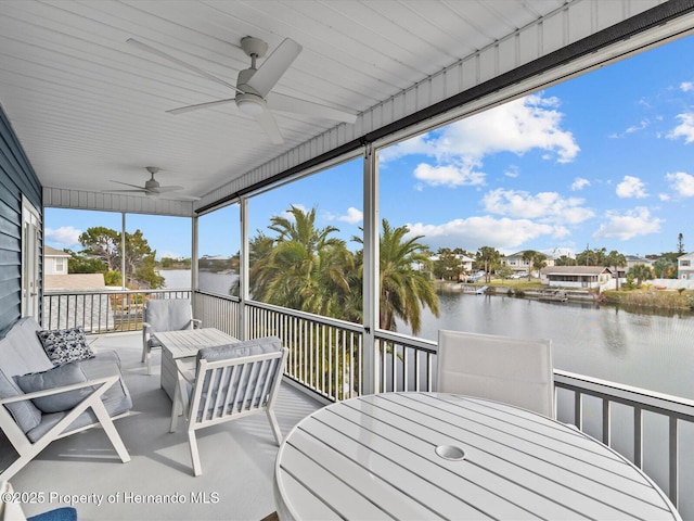 unfurnished sunroom with a water view and ceiling fan