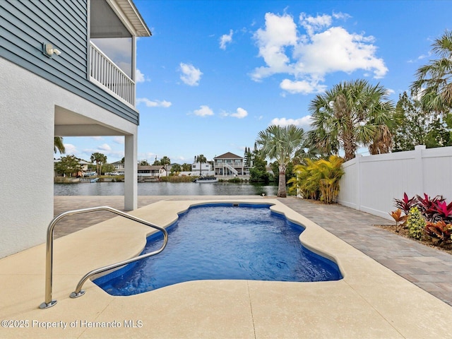 view of pool featuring a patio area and a water view