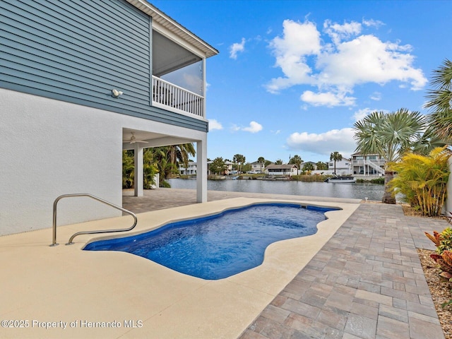 view of swimming pool featuring a patio area and a water view