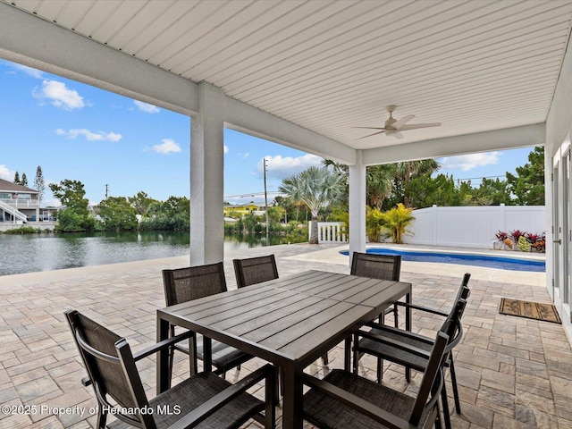 view of patio / terrace featuring ceiling fan, a fenced in pool, and a water view