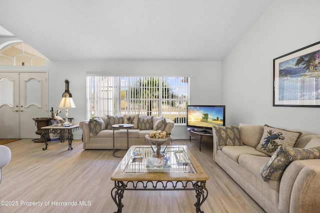 living room with light hardwood / wood-style floors and lofted ceiling