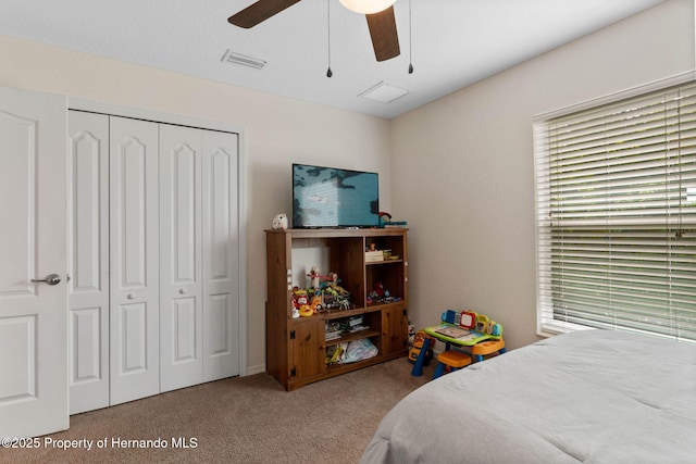 bedroom featuring ceiling fan, multiple windows, carpet, and a closet