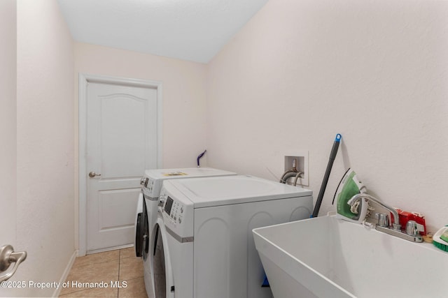 laundry area with sink, light tile patterned flooring, and washer and dryer