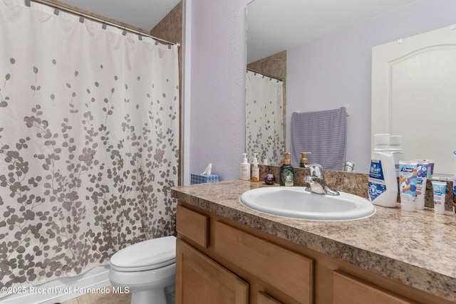 bathroom with toilet, vanity, and tile patterned flooring