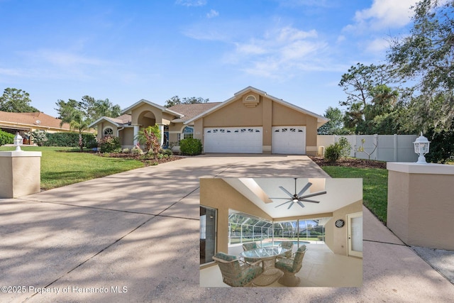 view of front of home with a garage, ceiling fan, and a front lawn