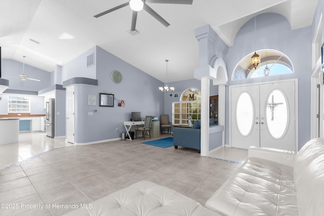 tiled entryway with french doors, high vaulted ceiling, ceiling fan with notable chandelier, and decorative columns