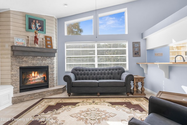 living room with light tile patterned flooring and a stone fireplace