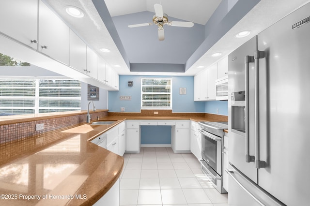 kitchen with appliances with stainless steel finishes, sink, white cabinets, and kitchen peninsula