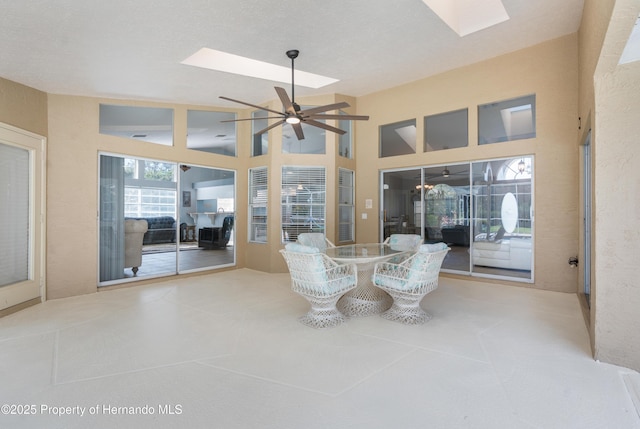 sunroom featuring ceiling fan and lofted ceiling with skylight