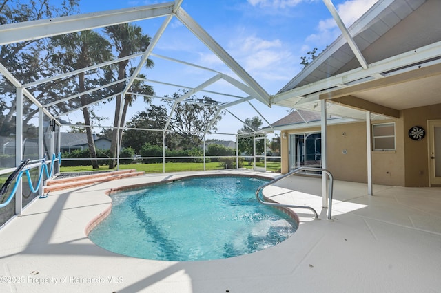 view of swimming pool featuring a yard, a lanai, and a patio area