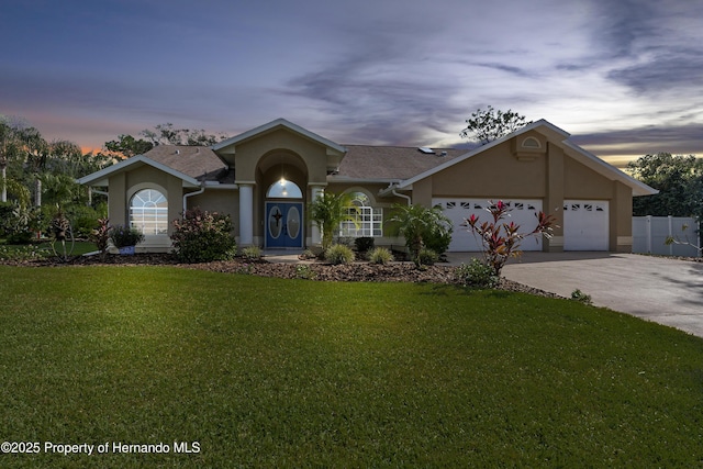 single story home featuring a garage and a yard