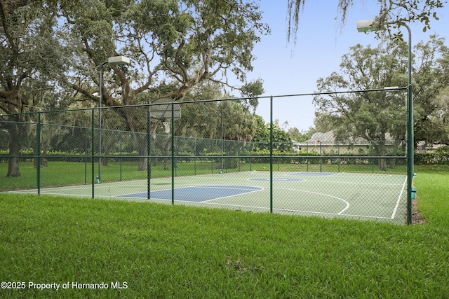 view of basketball court with a lawn