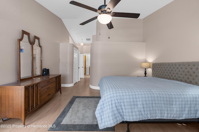 bedroom with ceiling fan, high vaulted ceiling, and light wood-type flooring