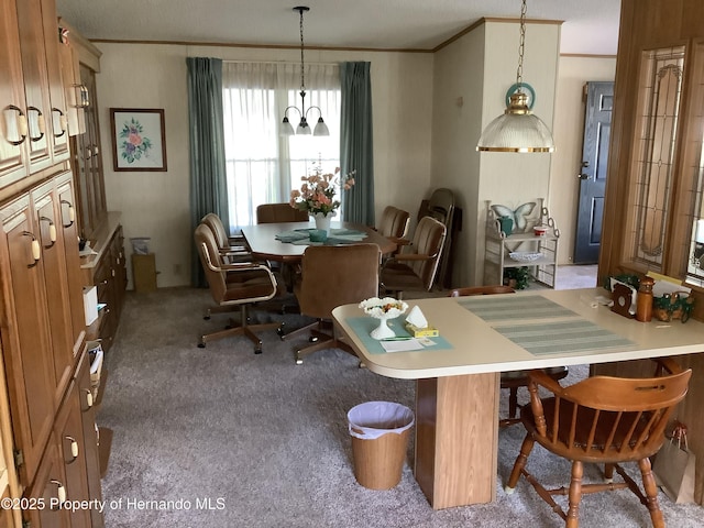 carpeted dining room featuring ornamental molding and an inviting chandelier