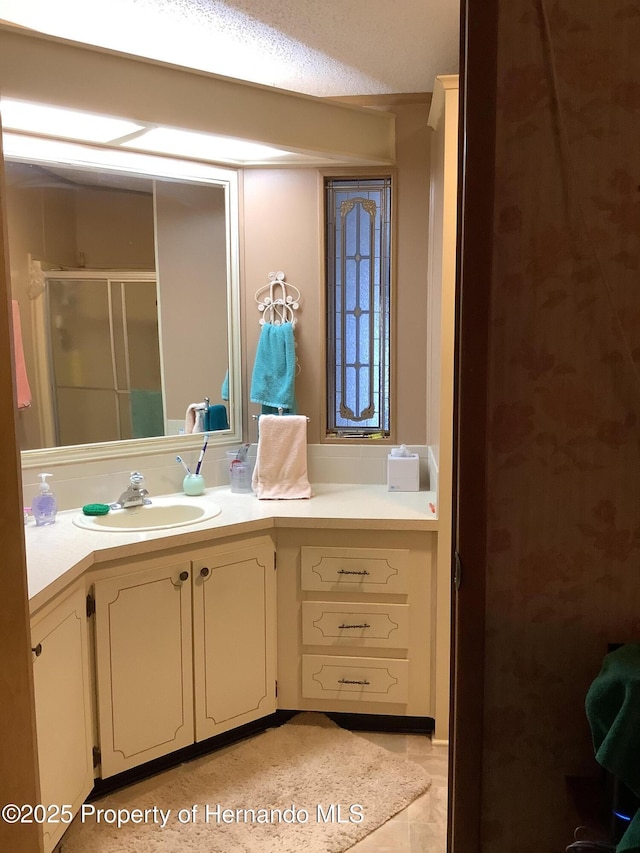 bathroom featuring vanity and a shower with door