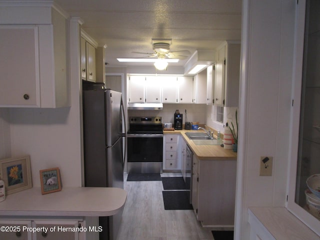 kitchen featuring light hardwood / wood-style floors, ceiling fan, appliances with stainless steel finishes, white cabinets, and sink