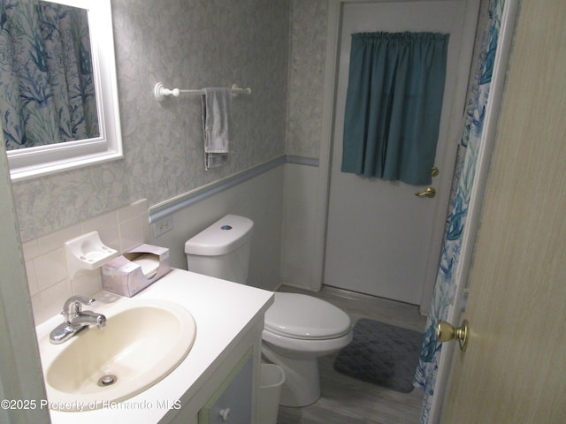 bathroom featuring toilet, vanity, a shower with shower curtain, and tasteful backsplash