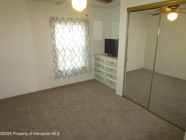 unfurnished bedroom with ceiling fan, a closet, and carpet floors