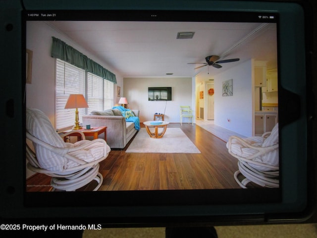 living room with hardwood / wood-style flooring, ornamental molding, and ceiling fan