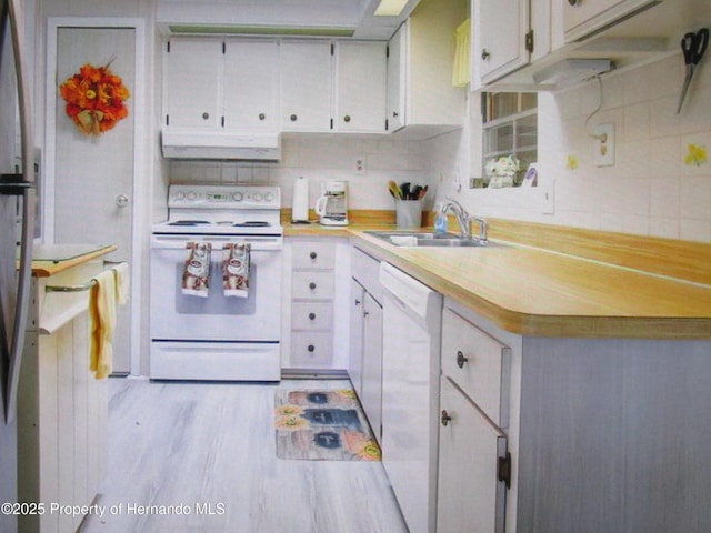 kitchen featuring white cabinets, sink, white appliances, and light hardwood / wood-style floors