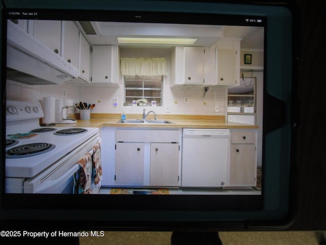 kitchen with sink, white appliances, and white cabinetry