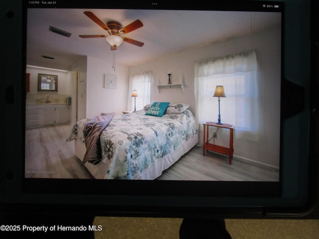 bedroom with ceiling fan and wood-type flooring