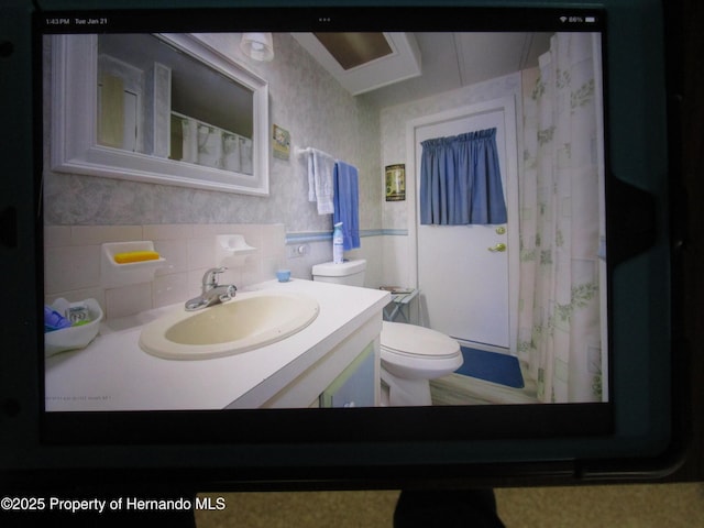 bathroom with toilet, vanity, and a shower with curtain