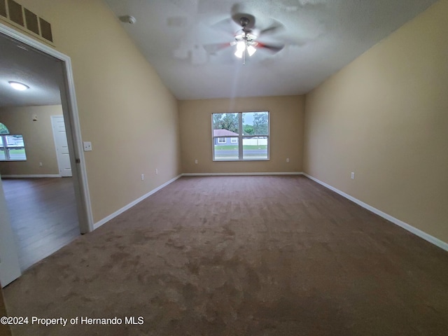 unfurnished room with ceiling fan and dark colored carpet