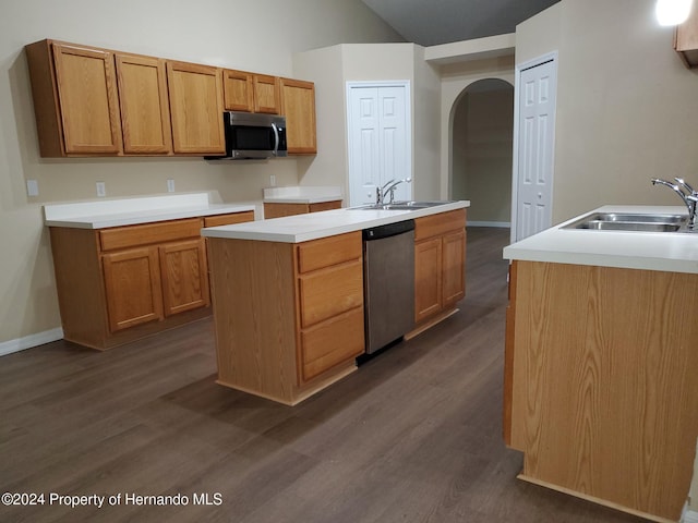 kitchen featuring lofted ceiling, stainless steel appliances, an island with sink, sink, and dark hardwood / wood-style floors