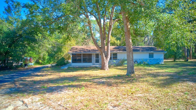 view of front of property with a front lawn and a sunroom