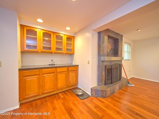 kitchen with light wood-type flooring and a fireplace