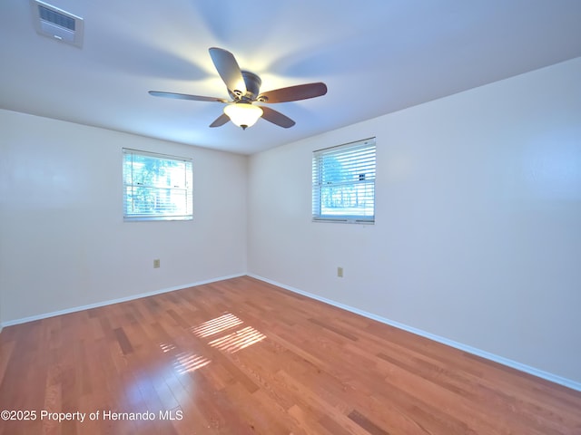 unfurnished room featuring a healthy amount of sunlight, light hardwood / wood-style flooring, and ceiling fan