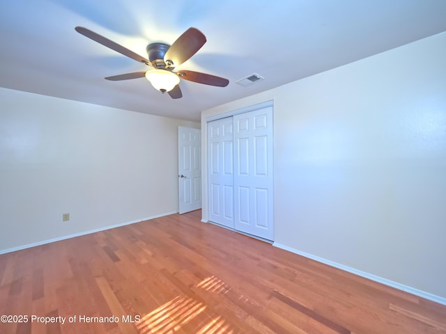 unfurnished bedroom with a closet, ceiling fan, and hardwood / wood-style flooring