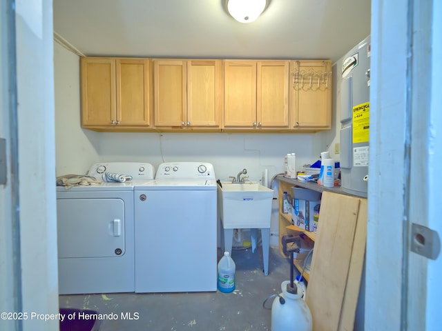 laundry room featuring sink, washer and clothes dryer, cabinets, and water heater