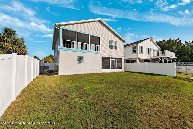 rear view of property with a sunroom and a lawn