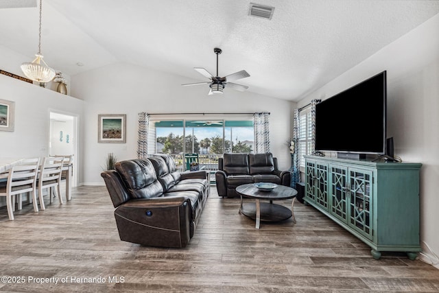 living room featuring lofted ceiling, hardwood / wood-style floors, and ceiling fan