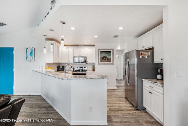 kitchen featuring hanging light fixtures, white cabinetry, appliances with stainless steel finishes, and kitchen peninsula